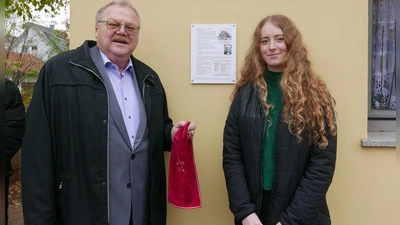 Bürgermeister Oswald Czech und Abiturientin Joana Lehr zeigen an einem Wohnhaus an der Bahnhofstraße die erste Gedenktafel. (Foto: Roman Kocholl)