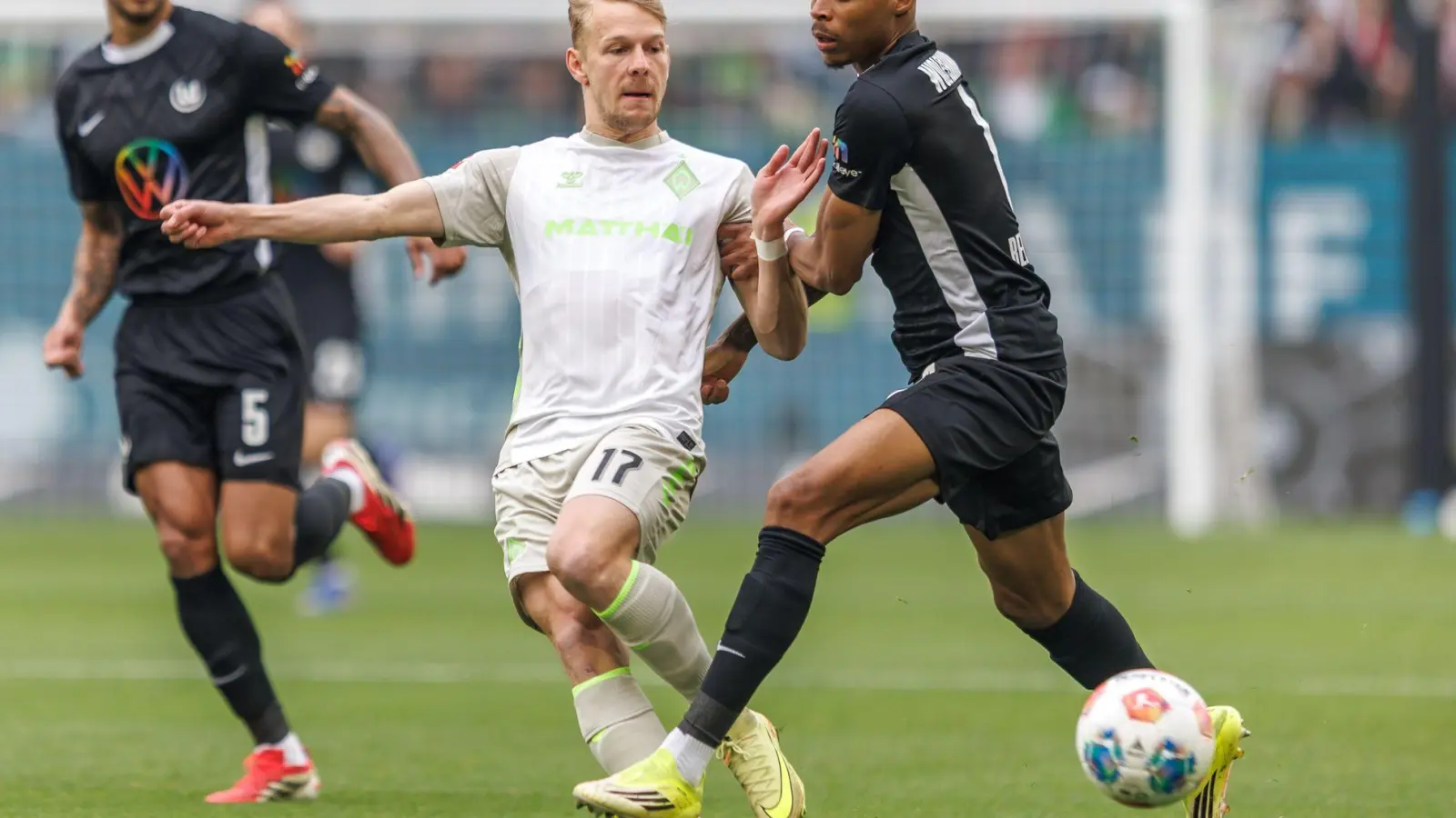 Werders Marco Grüll (l) wird von Wolfsburgs Jeanuel Belocian bedrängt. (Foto: Andreas Gora/dpa)