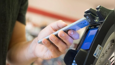 Im Vorbeigehen: Wer mit dem Smartphone Einkäufe zahlt, muss nicht nach Münzen oder Karten kramen. (Foto: Franziska Gabbert/dpa-tmn)