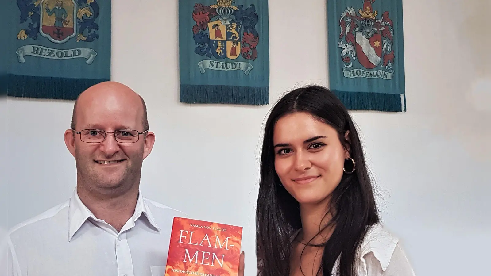 Oberbürgermeister Dr. Markus Naser und Nasila von Staudt mit ihrem neuen Buch und dem Familienwappen im Hintergrund. (Foto: Thomas Müller)