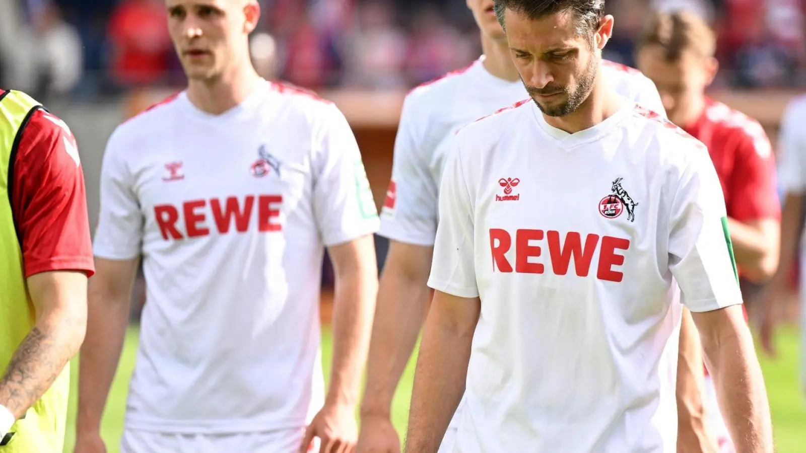 Die Kölner Spieler gehen nach der Niederlage in Heidenheim mit hängenden Köpfen vom Rasen. (Foto: Harry Langer/dpa)