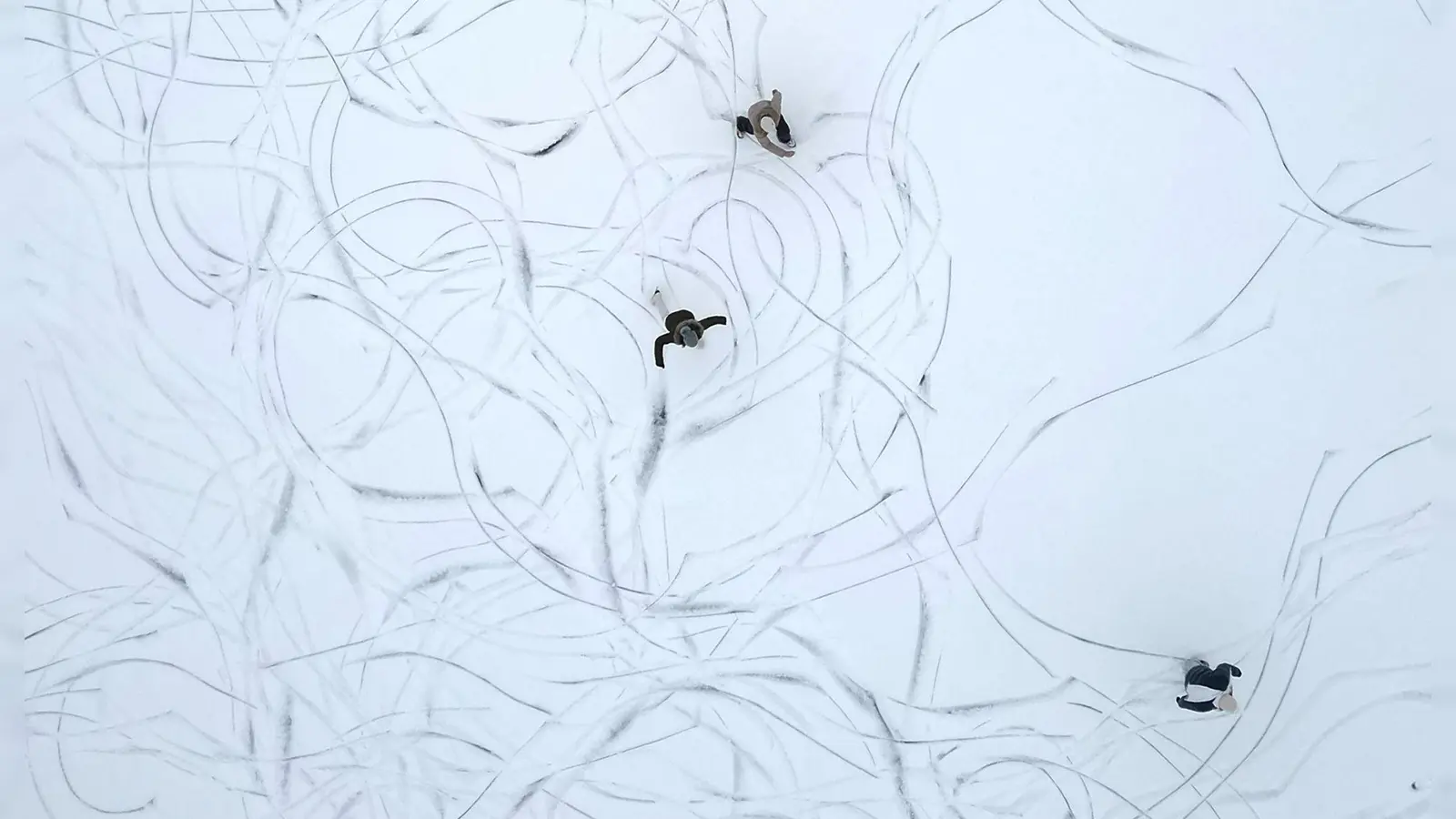 Muster im Schnee: Eine Luftaufnahme zeigt Schlittschuhläufer auf einem zugefrorenen See in Österreich. (Foto: Helmut Fohringer/APA/dpa)