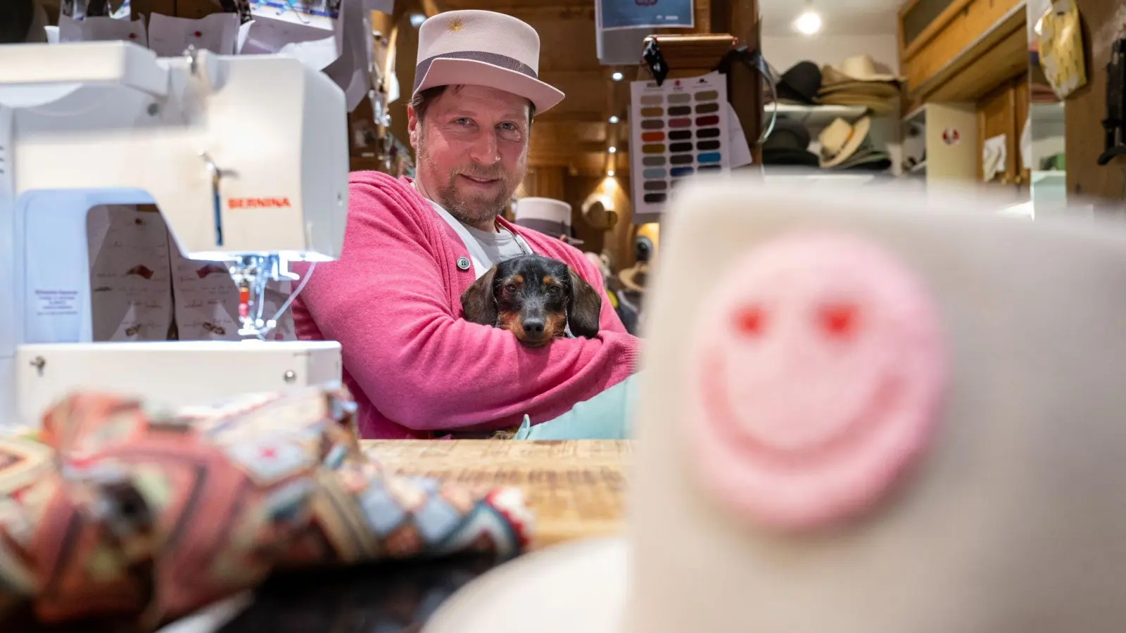 Der ehemalige Eishockey-Profispieler und jetzige Hutmacher Patrick Köppchen sitzt mit Hundedame Heidi in seinem Atelier und Ladengeschäft „Fatzke“ in der Innenstadt. (Foto: Peter Kneffel/dpa/Archivbild)