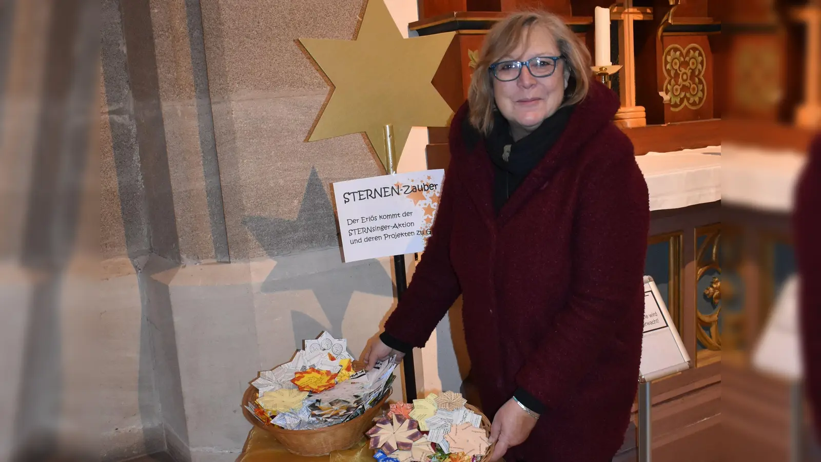 Gemeindereferentin Jutta Friedel zeigt die hübschen gebastelten Sterne, die darauf warten, gegen eine kleine Spende in der katholischen Kirche in Neustadt abgeholt zu werden. (Foto: Ute Niephaus)