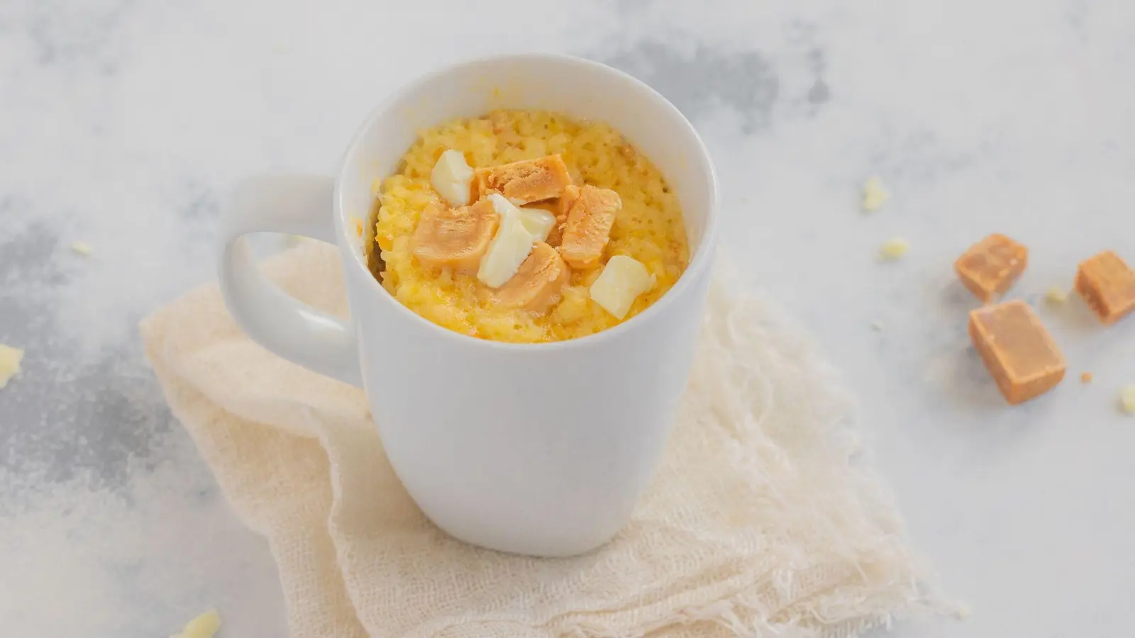 Dieser Tassenkuchen mit weißer Schokolade und Karamell von Back-Bloggerin Kathrin Runge steht innerhalb von ein paar Minuten auf dem Tisch. (Foto: Kathrin Runge/backenmachtguecklich.de/dpa-tmn)