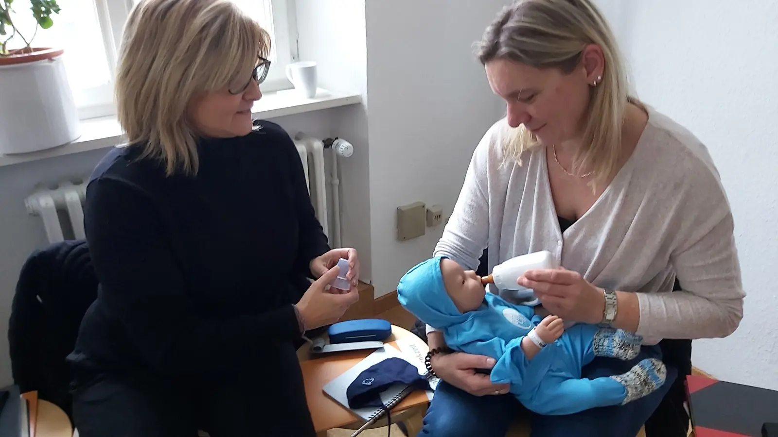 Der Umgang mit Leo wird zunächst mit einer erzieherischen Fachkraft der KoKi eingeübt: Kerstin Stöcker (rechts) mit einer der Koordinatorinnen von KoKi Sylvia Fichtelmann (links). (Foto: Landratsamt Neustadt / Manuela Stern)