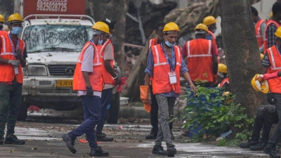 Arbeiter sind an der Absturzstelle im Einsatz. (Foto: Rafiq Maqbool/AP/dpa)