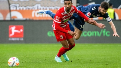 Augsburgs Noah Sarenren Bazee (l) und Kölns Jonas Hector liefern sich einen Zweikampf. (Foto: Stefan Puchner/dpa)