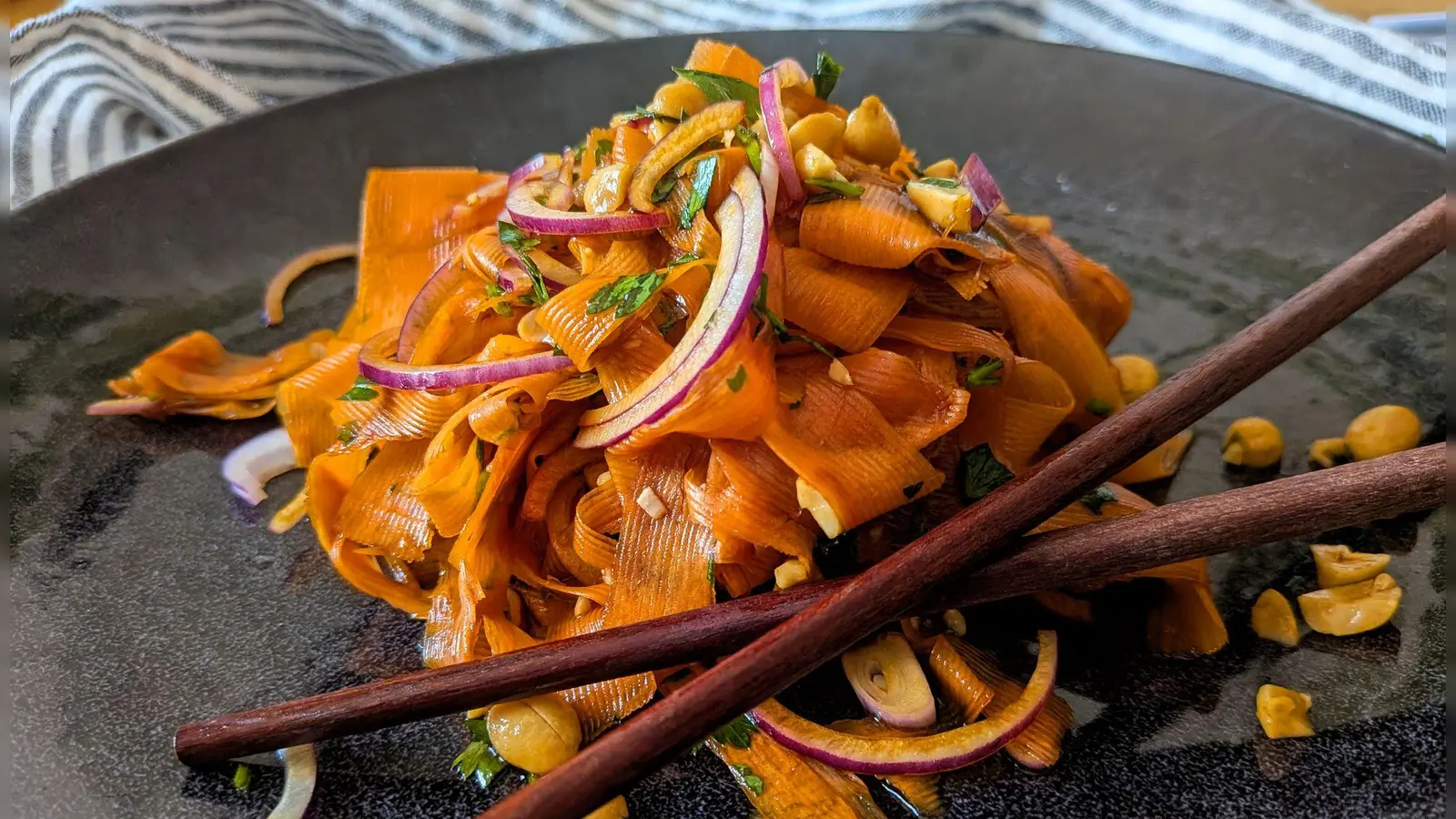 Für den Karottensalat im Asia-Style werden die Möhren nicht geraspelt, sondern mit dem Sparschäler gehobelt, bis nichts mehr von der Möhre übrig ist.    (Foto: Doreen Hassek/hauptstadtkueche.blogspot.com/dpa-tmn)