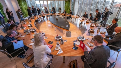 Die Minister und der Ministerpräsident sitzen zu Beginn der Sitzung des bayerischen Kabinetts gemeinsam am Tisch. (Foto: Peter Kneffel/dpa)