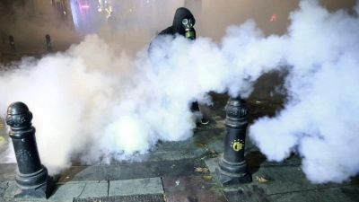 Georgien kommt nicht zur Ruhe: Ein Demonstrant mit einer Gasmaske steht in Tiflis in einer Tränengaswolke bei wütenden Protesten gegen die Entscheidung der Regierung, die Verhandlungen über den Beitritt zur Europäischen Union auszusetzen. (Foto: Zurab Tsertsvadze/AP/dpa)