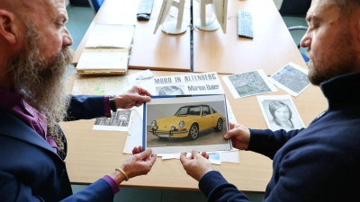 In solch einem Auto - das Bild ist KI-generiert - soll der Täter laut Zeugenaussagen mit Marion Baier vor der Tat gestritten haben. Gehalten wird es von Patrick Merten (r), Leiter des Cold Case „Marion Baier“ und Michael Dietsch, Leiter der Kripo Fürth. (Foto: Daniel Löb/dpa)