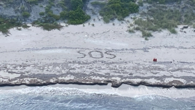„SOS“: Ein 64-jähriger Mann war drei Tage lang auf einer Insel in den Bahamas gestrandet. (Foto: Uncredited/U.S. Coast Guard/AP/dpa)