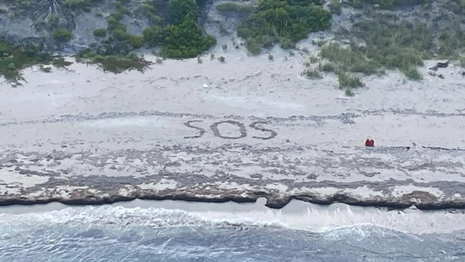 „SOS“: Ein 64-jähriger Mann war drei Tage lang auf einer Insel in den Bahamas gestrandet. (Foto: Uncredited/U.S. Coast Guard/AP/dpa)