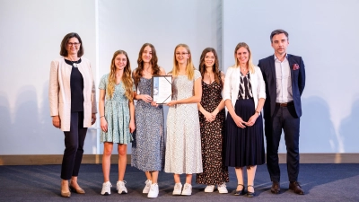 Siegerfoto in München mit (von links) Landtagspräsidentin Ilse Aigner, den Schülerinnen Joela Niemann, Lena Serby, Lena Hoch und Lucia Hertlein, Lehrerin Simone Lindner und Florian Neubauer (Landeswettbewerbsleiter im Auftrag des Kultusministeriums). (Foto: StMUK/Matthias Balk)