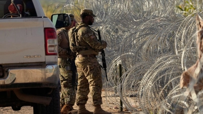 Soldaten stehen neben einem Stacheldrahtzaun am Ufer des Rio Grande Wache. (Foto: Eric Gay/AP/dpa)