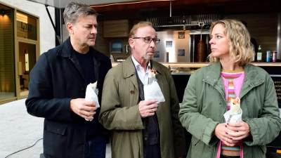 Harald Neuhauser (l, Marcus Mittermeier), Ludwig Schaller (Alexander Held) und Angelika Flierl (Bernadette Heerwagen) stehen vor einem Imbissstand. (Foto: Jürgen Olczyk,/ZDF/dpa)