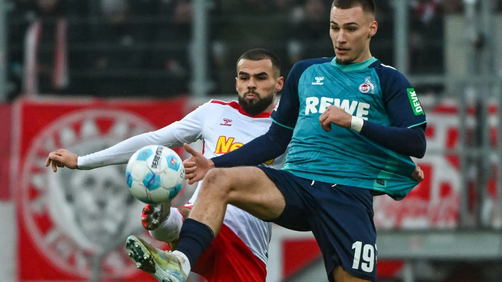 Der Kölner Tim Lemperle (rechts) und Robin Ziegele von Regensburg kämpfen um den Ball. (Foto: Armin Weigel/dpa)