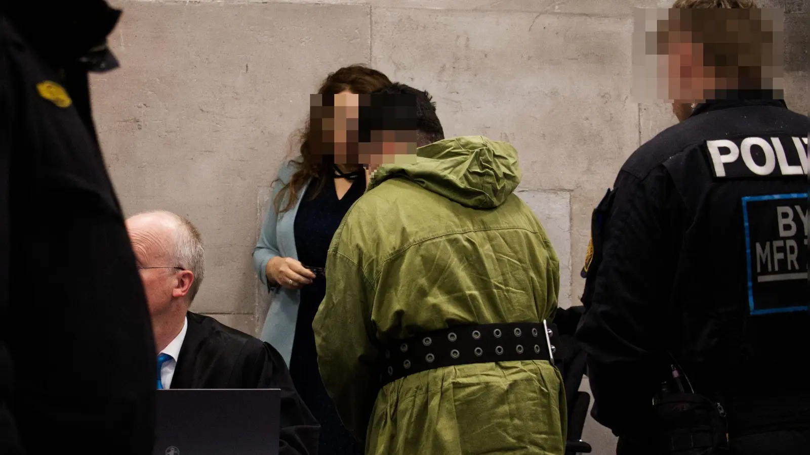 Polizisten waren an der Seite des Angeklagten, um ihn nach Todesdrohungen zu schützen. Er musste nicht nur Fußfesseln, sondern auch Handfesseln, die in einem breiten Gürtel fixiert waren, tragen, als er neben einer Dolmetscherin Platz nahm.  (Foto: René Chlopotowski)