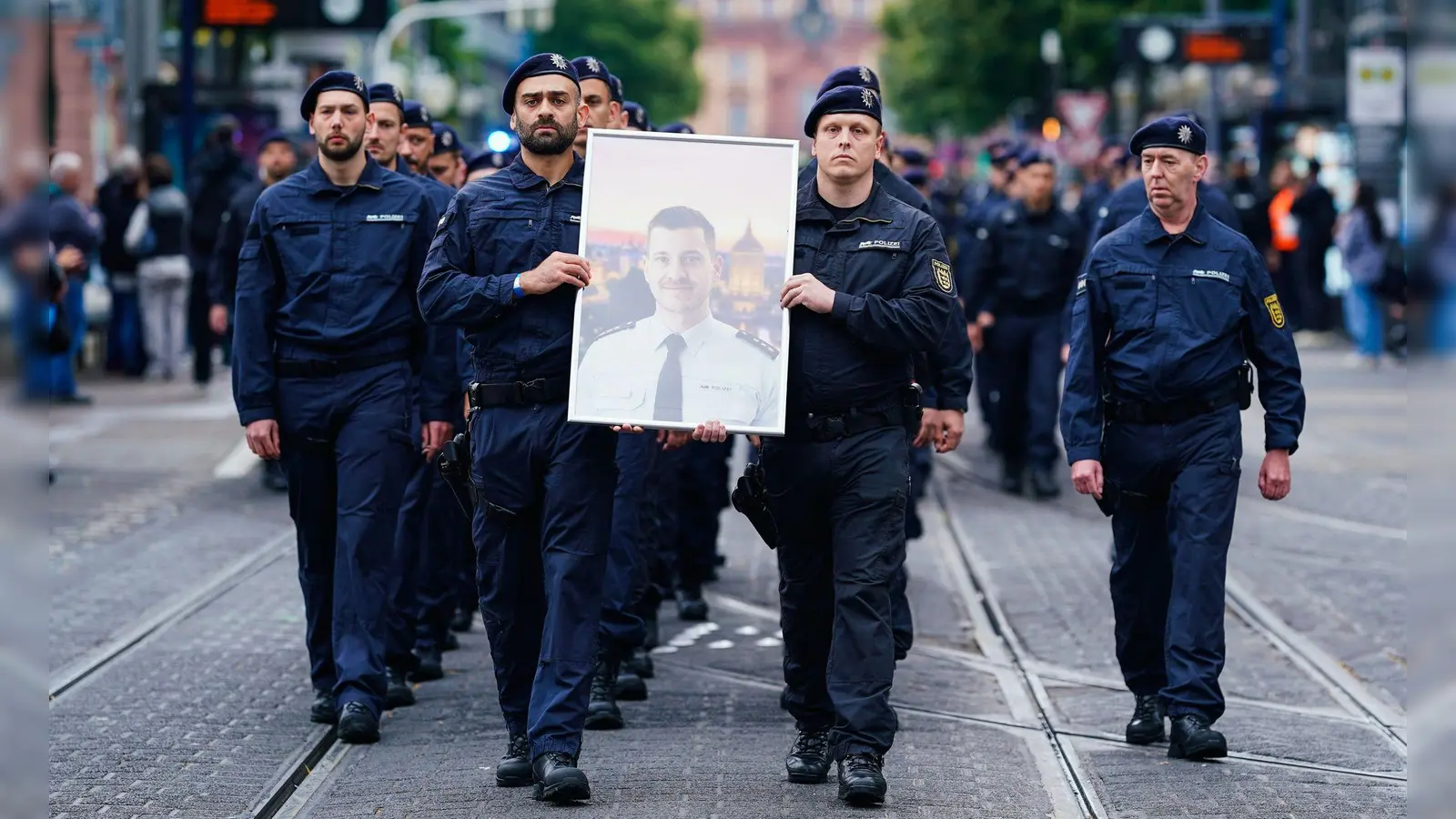 In Gedenken an ihren tödlich verletzten Kollegen Rouven Laur ziehen Polizisten durch die Mannheimer Innenstadt. (Foto: Uwe Anspach/dpa)