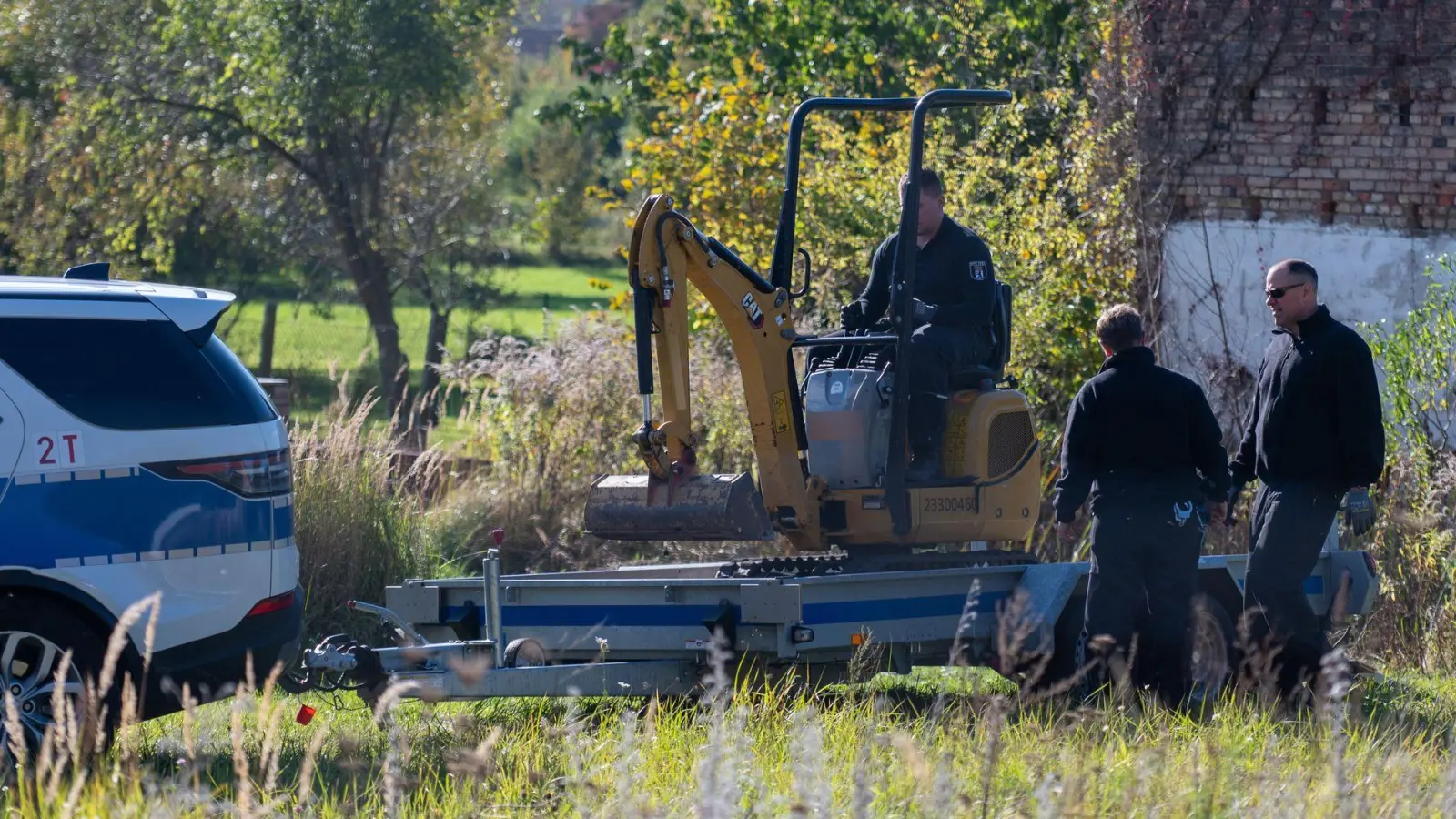 Polizisten untersuchen mit einem Bagger ein Grundstück in Herzberg (Landkreis Oder-Spree). (Foto: Christophe Gateau/dpa)