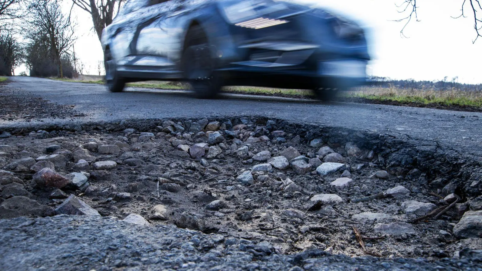 Wer mit hohem Tempo durch ein Schlagloch fährt, riskiert Schäden an Lenkung, Radaufhängung, Reifen und Felgen. (Foto: Jens Büttner/dpa/dpa-tmn)