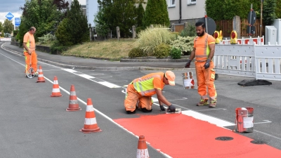 Am Montagnachmittag liefen noch letzte Markierungsarbeiten – mit dem roten Farbtopf wurde die Fahrradspur eingezeichnet. Im Laufe des Dienstags soll aber alles rundum abgeschlossen sein. (Foto: Ute Niephaus)