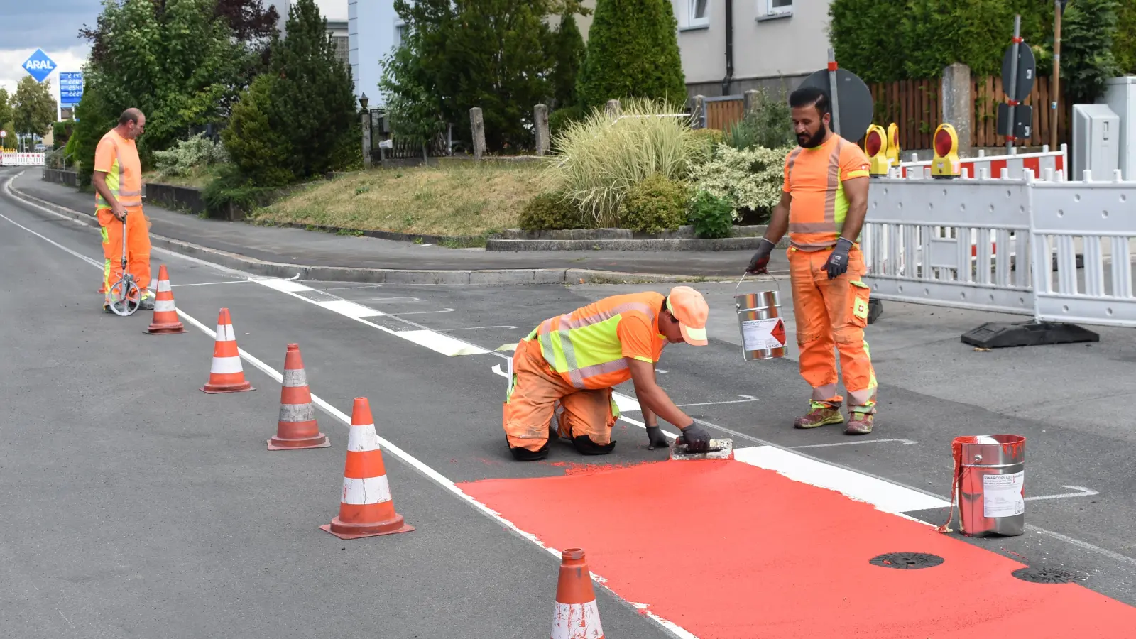 Am Montagnachmittag liefen noch letzte Markierungsarbeiten – mit dem roten Farbtopf wurde die Fahrradspur eingezeichnet. Im Laufe des Dienstags soll aber alles rundum abgeschlossen sein. (Foto: Ute Niephaus)