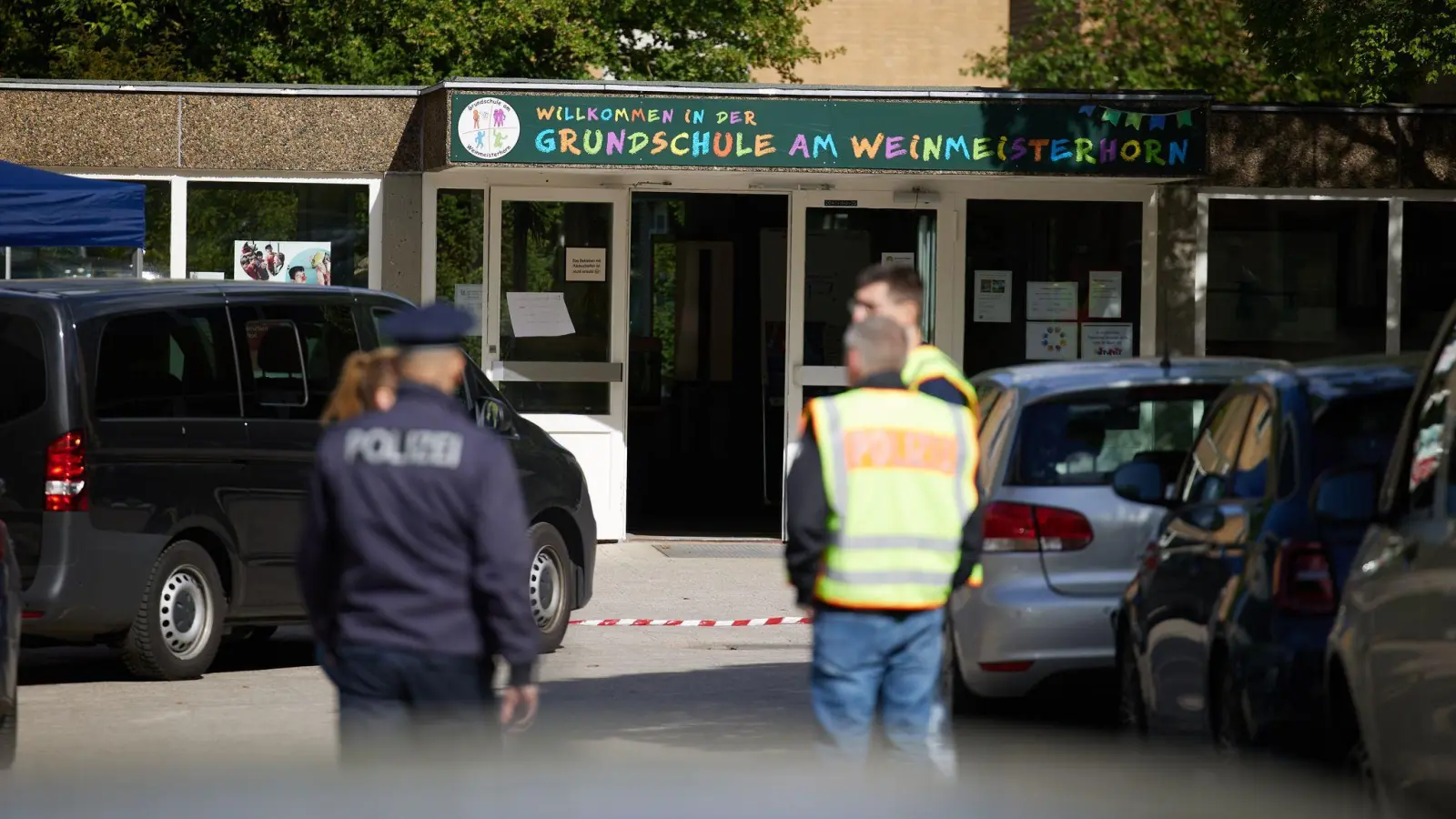 Polizisten stehen vor einer Schule in Spandau, an der es am Donnerstag einen Messerangriff auf einen Schüler gab.  (Foto: Jörg Carstensen/dpa)