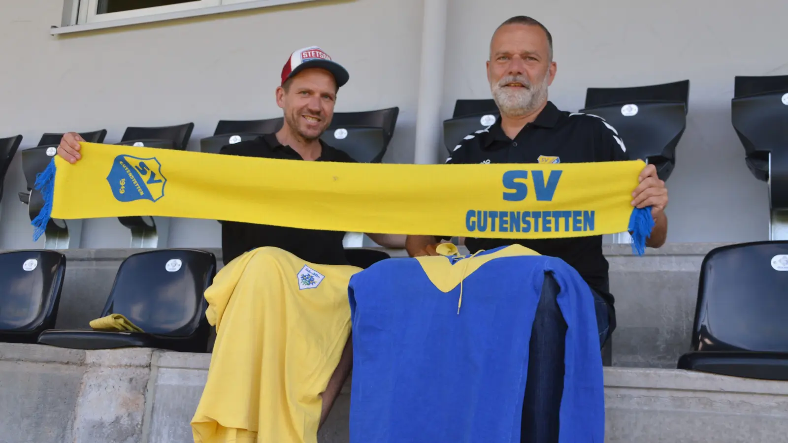 Mit Fan-Schal und historischen Trikots haben es sich Sven Zeh (links) und Dietmar Gahm auf der Tribüne bequem gemacht. Die Vorfreude auf das Fest-Wochenende ist groß. (Foto: Johannes Zimmermann)