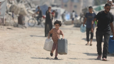 Ein Kind trägt Kanister, um sich in Gaza Wasser von einem Tankwagen zu holen. (Foto: Omar Ashtawy/APA Images via ZUMA Press Wire/dpa)