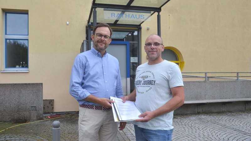 Andreas May (rechts) ist Anwohner im Kernort von Wilburgstetten. Im Namen von 106 Bürgerinnen und Bürgern überreichte er den Antrag auf eine Temporeduzierung im Wohnbereich an Bürgermeister Michael Sommer (links). (Foto: Peter Tippl)