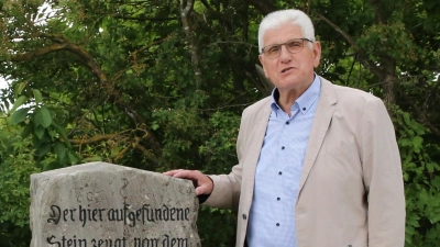 Stadtrat Joseph Hillermeier präsentiert den Gedenkstein, der an den Bau der Urlasstraße Ende des 19. Jahrhunderts erinnert. (Foto: Alexander Biernoth)