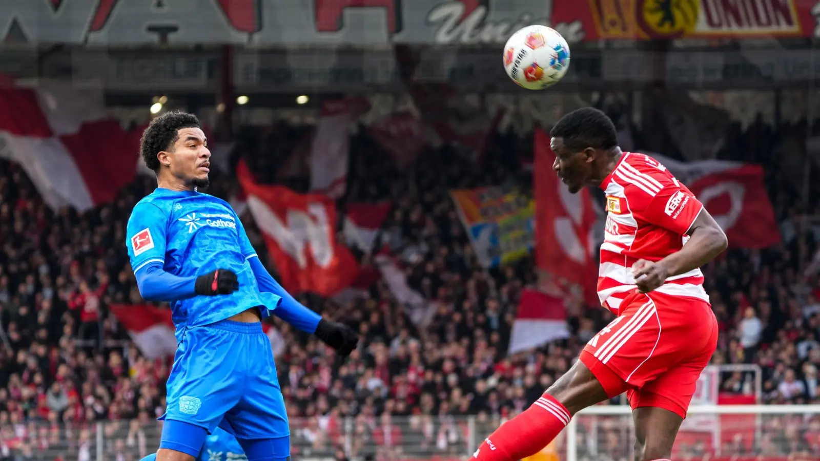 Union Berlins Nsoki (r.) setzt sich im Kopfballduell mit Leverkusens Tillmann (l.) durch.  (Foto: Soeren Stache/dpa)