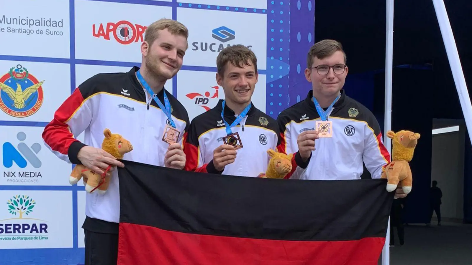 Mit Fahne, Bronzemedaille und Stofftier: Das Junioren-Trio Nils Palberg, Justus Ott und Florian Beer (von links) bei der Siegerehrung in Lima. (Foto: Alyssa Ott)