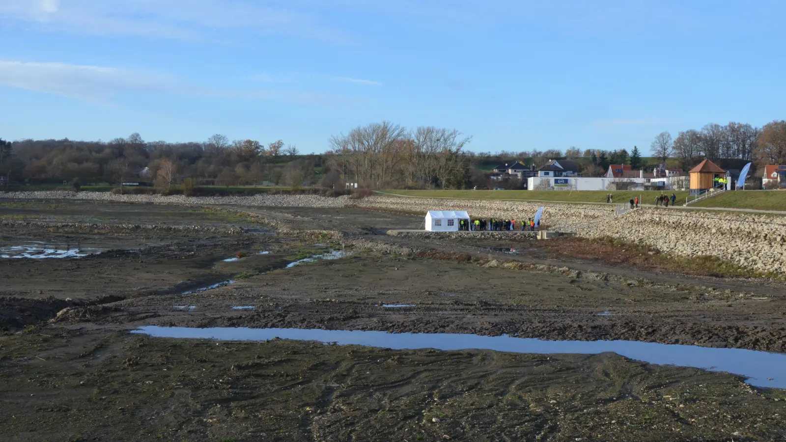 Festakt auf dem Seegrund: Nach dem Wiederverschluss der Schieber im Damm des Hochwasserrückhaltebeckens Obernzenner See wird über die kommenden Monate der frühere Wasserspiegel wieder hergestellt. (Foto: Yvonne Neckermann)