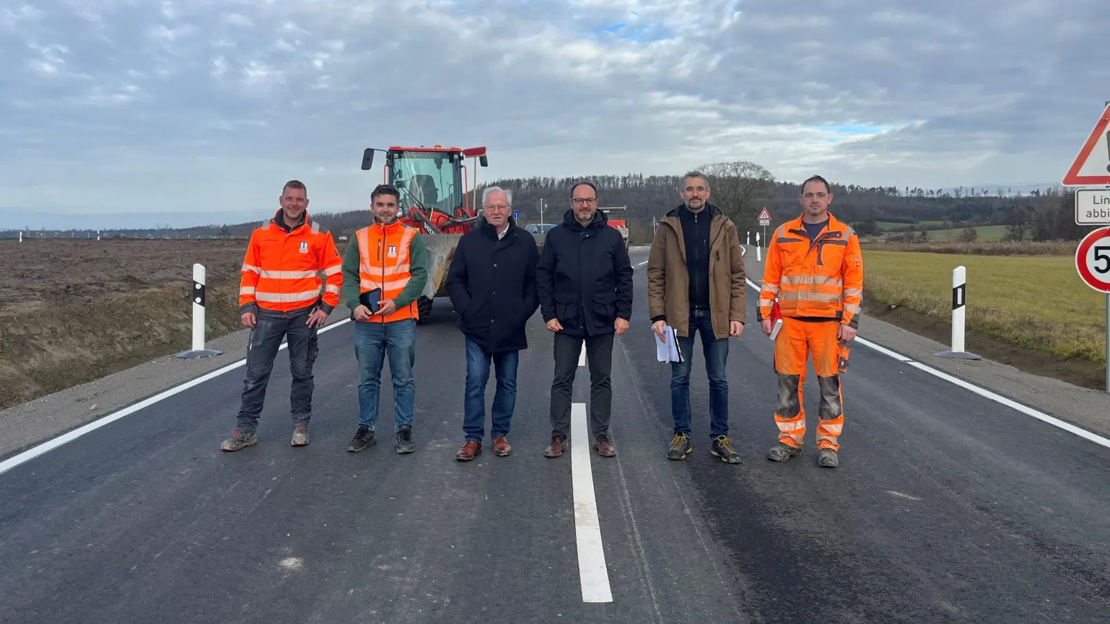 Auch der vierte Abschnitt der Erschließungsstraße ist jetzt fertig. Das Foto zeigt Bürgermeister Jürgen Geier (Dritter von rechts) mit Vertretern der Baufirma, des Planungsbüros und des Bauhofs an dem neuen Teilstück. (Foto: Gemeinde Dombühl)