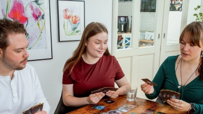 Bei Spiel „Boss Fighters QR“ trifft ein klassisches Kartendeckbauspiel auf eine App, die mittels QR-Codes auf den Karten auf die Entscheidungen am Tisch reagiert. Ziel ist es, als Team nacheinander verschiedene Monster zu besiegen.  (Foto: Pegasus Spiele/dpa-tmn)