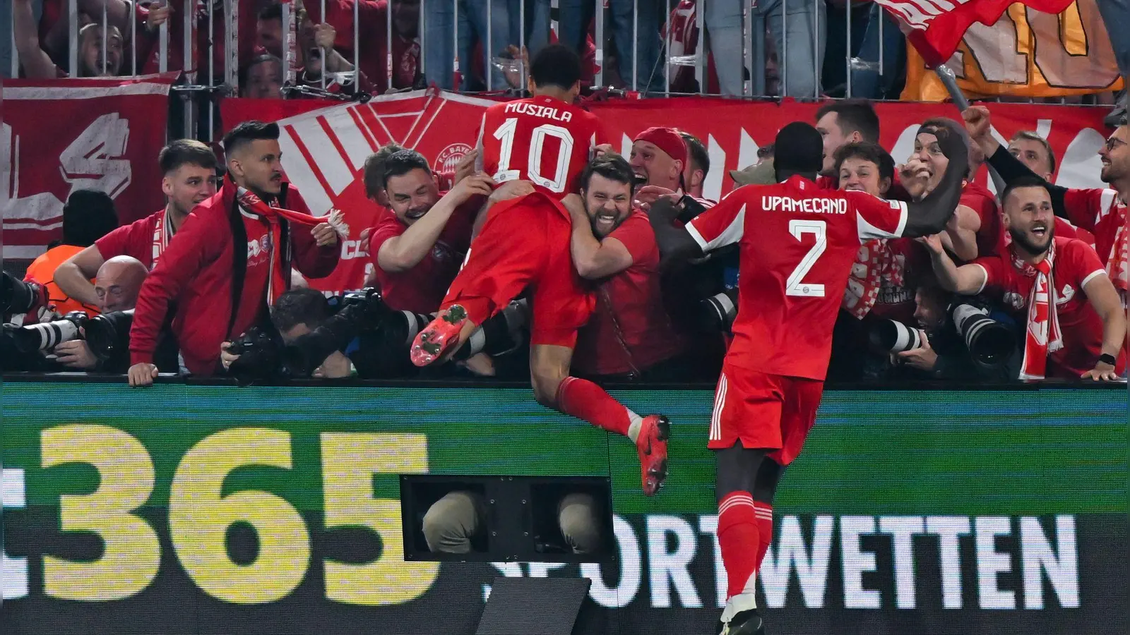 Nach dem letzten Bayern-Tor gegen Real springen einige Münchner Fans und Bayern-Profi Jamal Musiala im Jubel den anwesenden Fotografen in den Rücken. (Foto: Sven Hoppe/dpa)