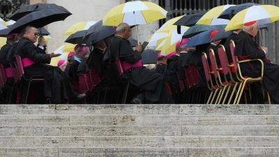 Nasse Segensstunde: Geistliche mit Schirmen bei Papst Leo XIV.“ (Foto: Andrew Medichini/AP/dpa)