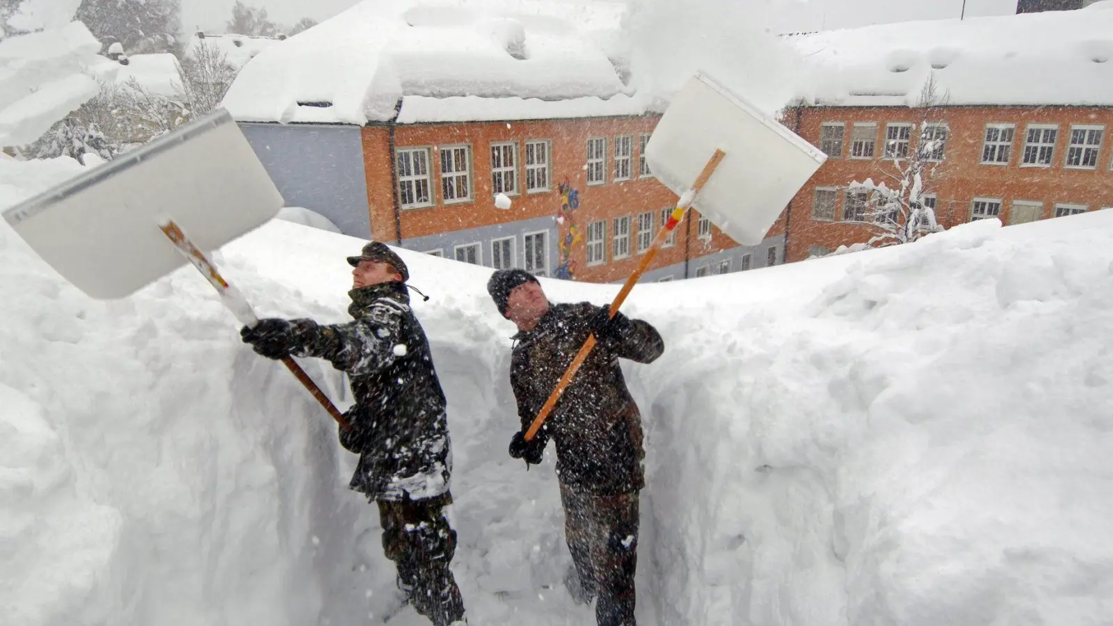 In Zwiesel mussten 2006 Bundeswehrsoldaten Schnee vom Dach einer Schule schaufeln. (Archivbild) (Foto: Armin Weigel/dpa)