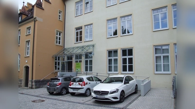 Das Erdgeschoss des Rathauses II ist über einen barrierefreien Aufgang zu erreichen, die anderen Stockwerke bislang nur über Treppen. Geplant ist die Errichtung eines Außenaufzugs. Diesem zum Opfer fallen würde der Parkplatz gleich an der Treppe.  (Foto: Jasmin Kiendl)
