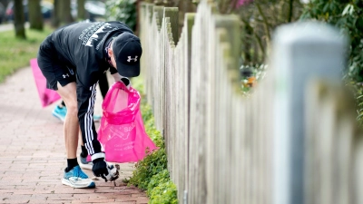 Aus der Sporteinheit eine gute Sache für die Umwelt machen: Beim Plogging wird Jogging und Müllsammeln kombiniert. (Foto: Hauke-Christian Dittrich/dpa/dpa-tmn)