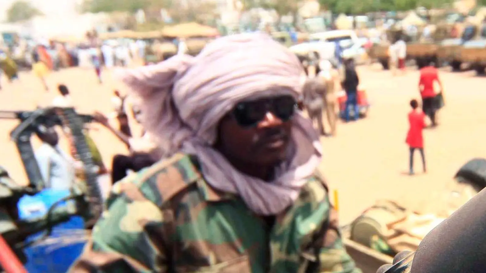 Ein Milizionär mit militärischer Ausrüstung, die angeblich während eines Gefechts im umkämpften Gebiet in Süd-Darfur erbeutet wurde (Archivbild). (Foto: Marwan Ali/epa/dpa)
