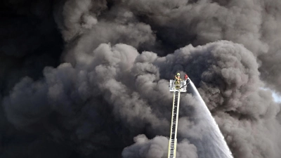Kampf gegen das Feuer: Feuerwehrleute löschen den Brand einer Lagerhalle mit Müll in der Gemeinde Swisttal bei Bonn. (Foto: Federico Gambarini/dpa)