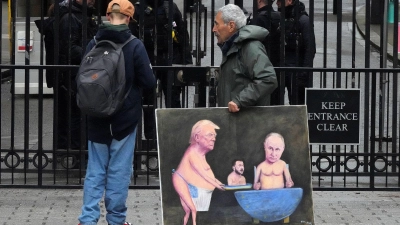 Ein Künstler geht in London mit einem Gemälde von Trump, Selenskyj und Putin am Tag der Ukraine-Gespräche vor den Toren der Downing Street 10 entlang.  (Foto: Frank Augstein/AP/dpa)
