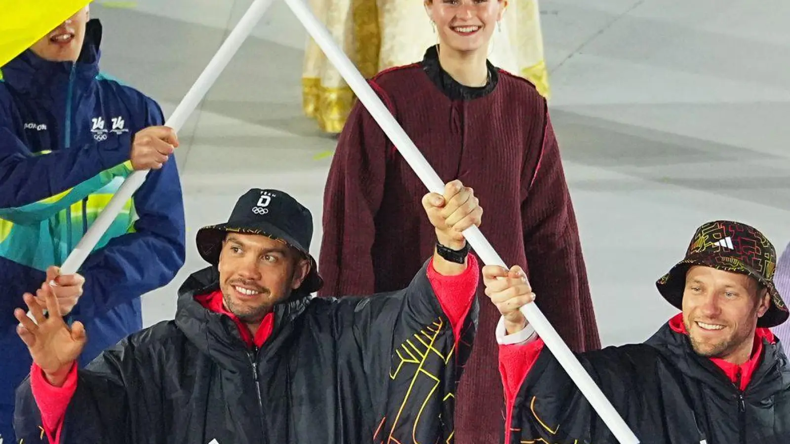 Tobias Wendl (l) und Tobias Arlt tragen die deutsche Fahne.  (Foto: Michael Kappeler/dpa)