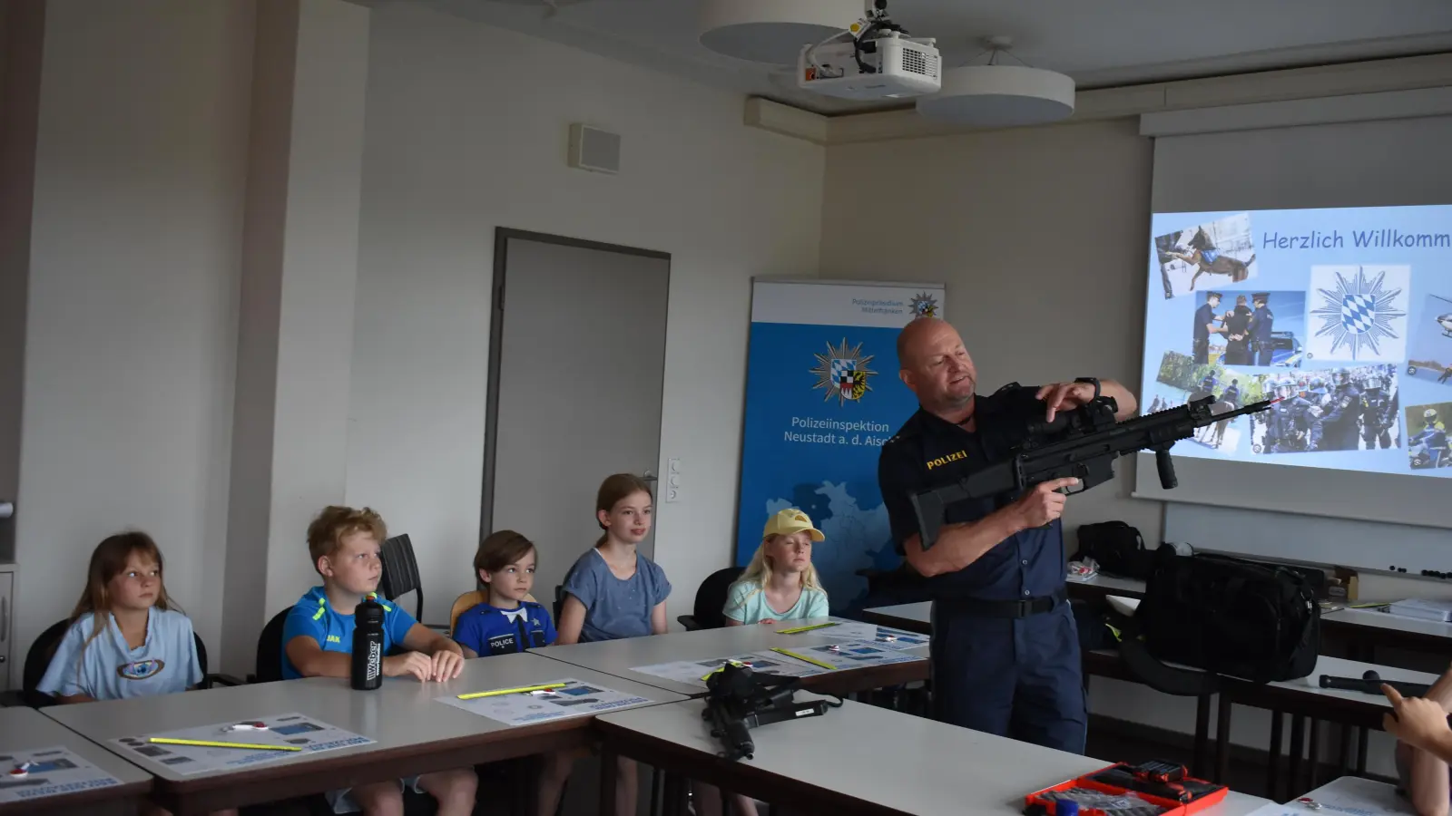 Roland Lichteneber erklärte den Kindern im Rahmen des Ferienprogramms auch, welche Waffen es bei der Neustädter Polizei gibt. Hier war natürlich nur das Anschauen aus der Distanz erlaubt. (Foto: Ute Niephaus)