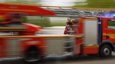 Ein Feuerwehrfahrzeug mit Drehleiter fährt zu einem Einsatz. (Foto: Robert Michael/dpa-Zentralbild/dpa/Archivbild)