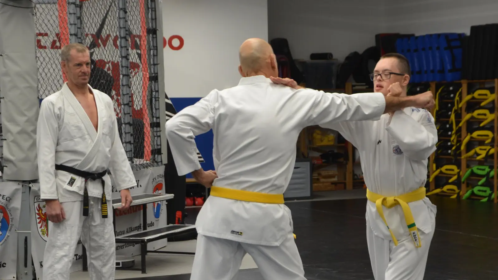 Im Trainingsraum der Taekwondo-Abteilung des DTV Diespeck. Hinten Trainer Holger Tanzberger und vorne Christian Tanzer und sein Sohn Joni, der trotz Downsyndrom ein guter Kampfsportler wurde und wird.  (Foto: Christa Frühwald)